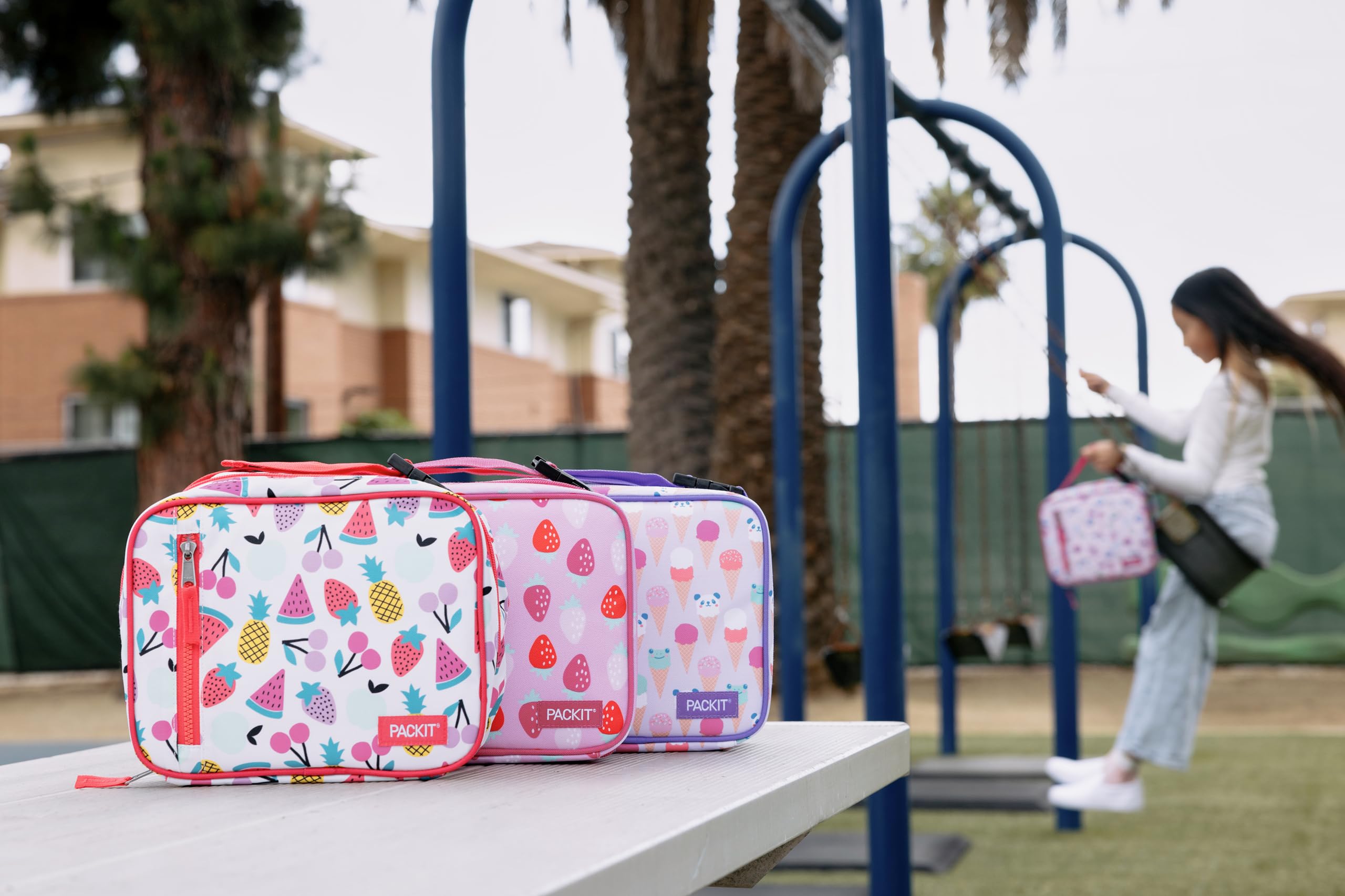 PackIt lifestyle shot at school lunch table showing bright Rainbow Sky design and chilled food
