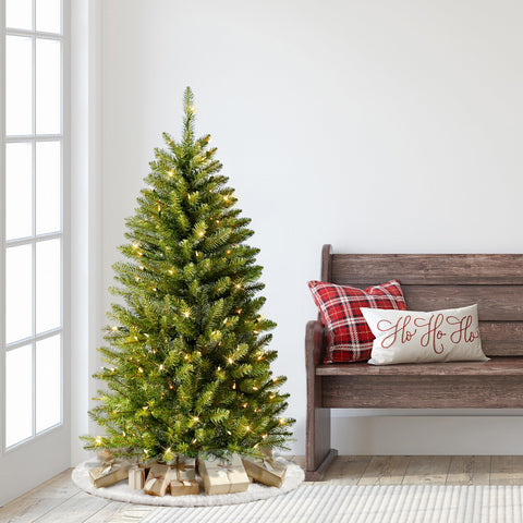 Puleo International tree beside sofa showing 4.5ft scale and space-saving narrow silhouette