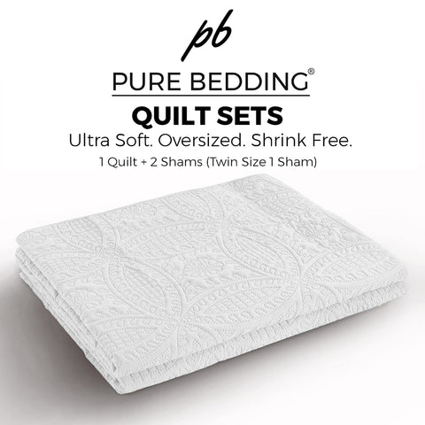 Pure Bedding folded quilt beside suitcase showing travel-friendly lightweight benefit