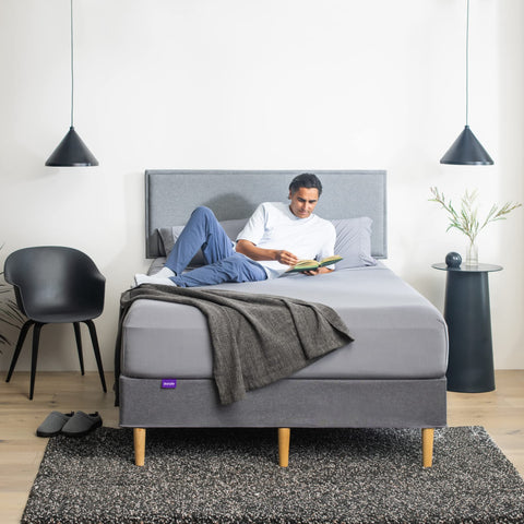 Purple fitted sheet stretched on mattress illustrates secure fit and neat corners