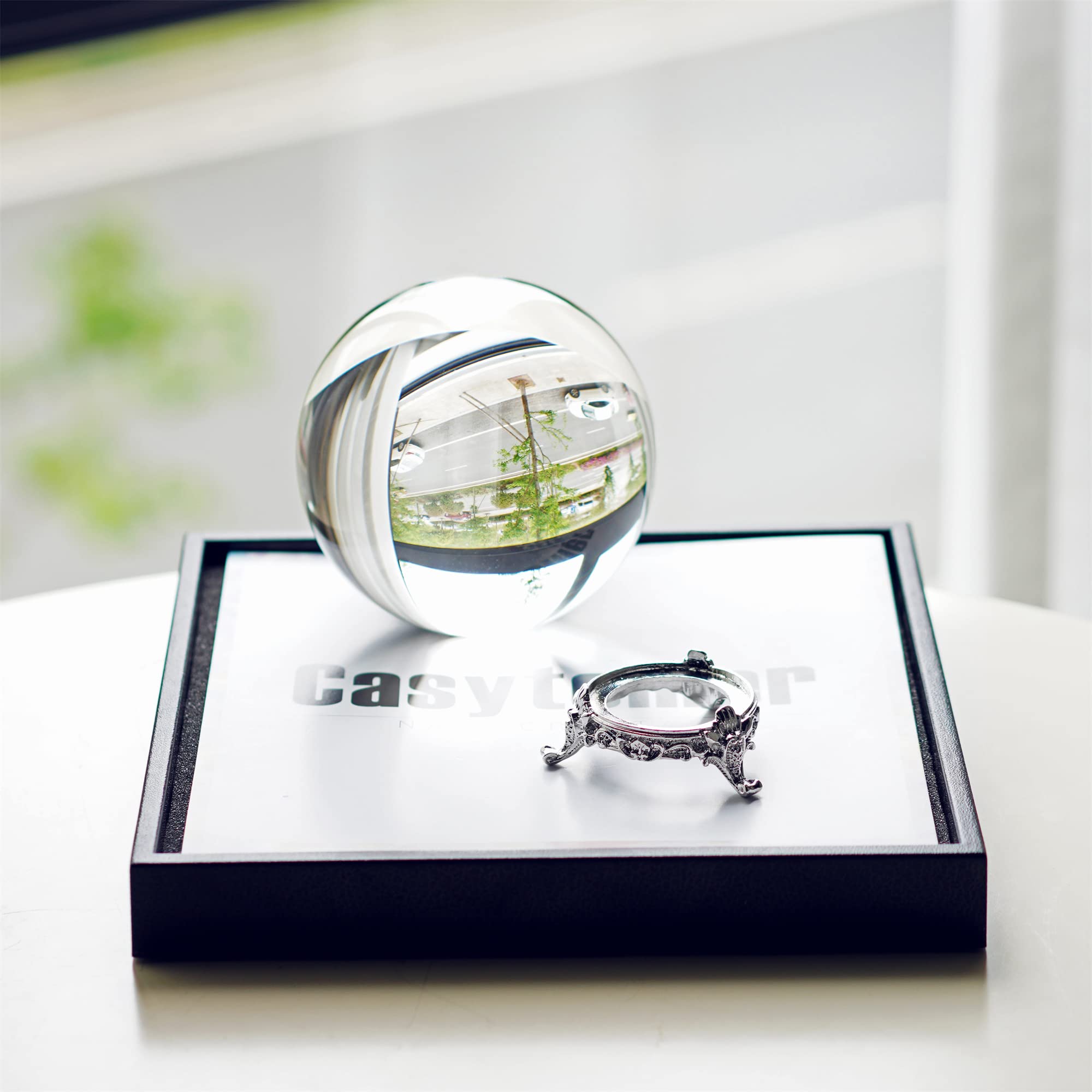 QFkris crystal ball beside a hand demonstrating 100mm scale and solid feel