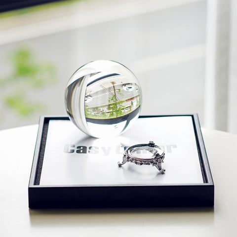 QFkris crystal ball beside a hand demonstrating 100mm scale and solid feel