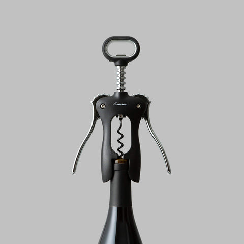 Rabbit classic wing corkscrew next to wine bottle for scale showing universal fit and size