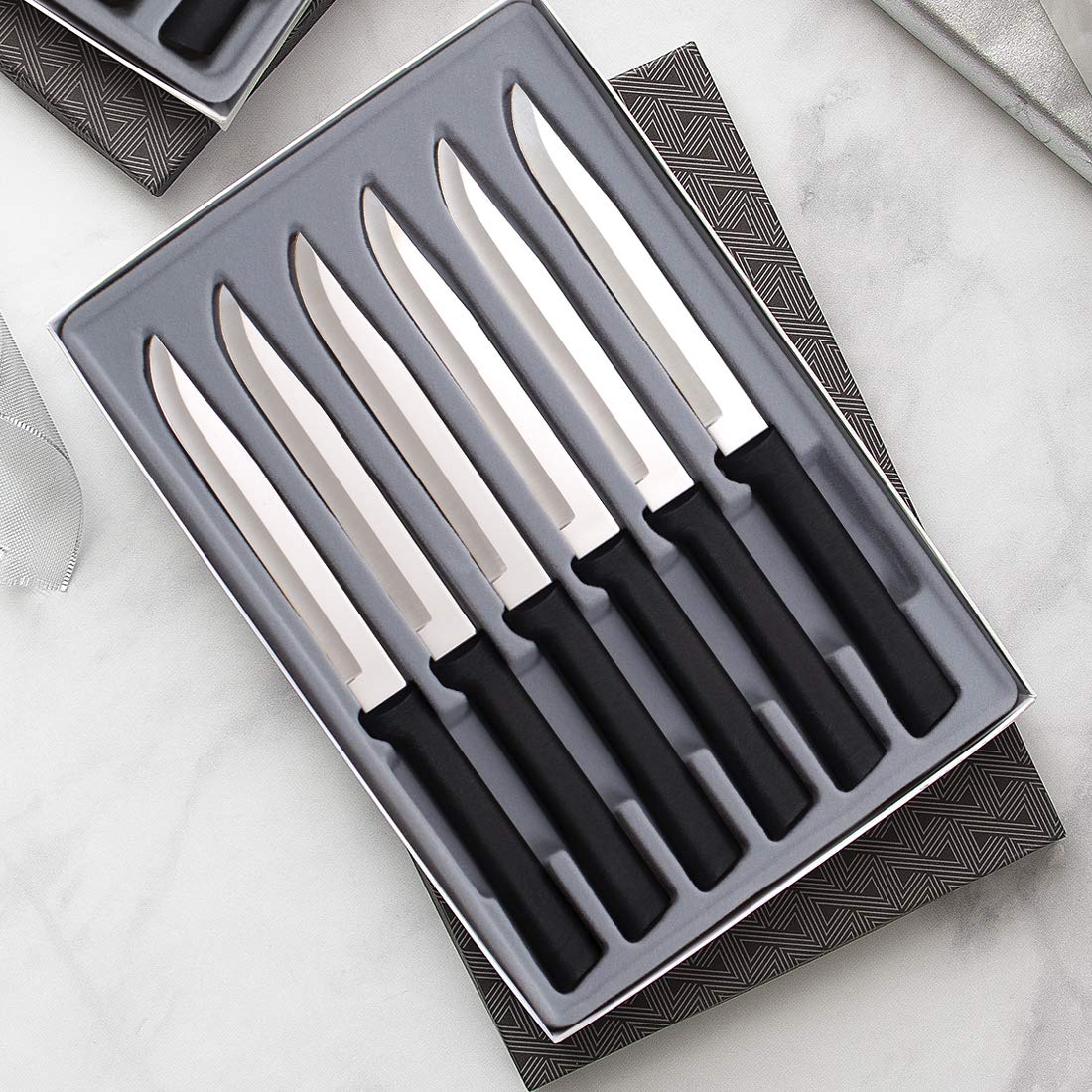 RADA knives on a dinner table slicing steak, showing comfortable handles and clean cuts