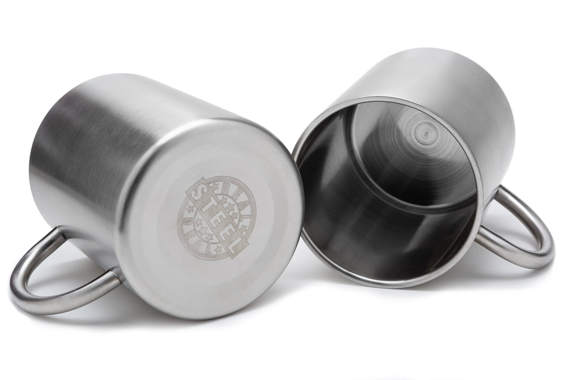 Real Deal Steel mugs beside campfire illustrating outdoor durability and usability