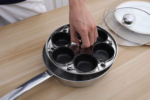 RUNZI removable poaching cups being lifted out showing dishwasher-safe convenience