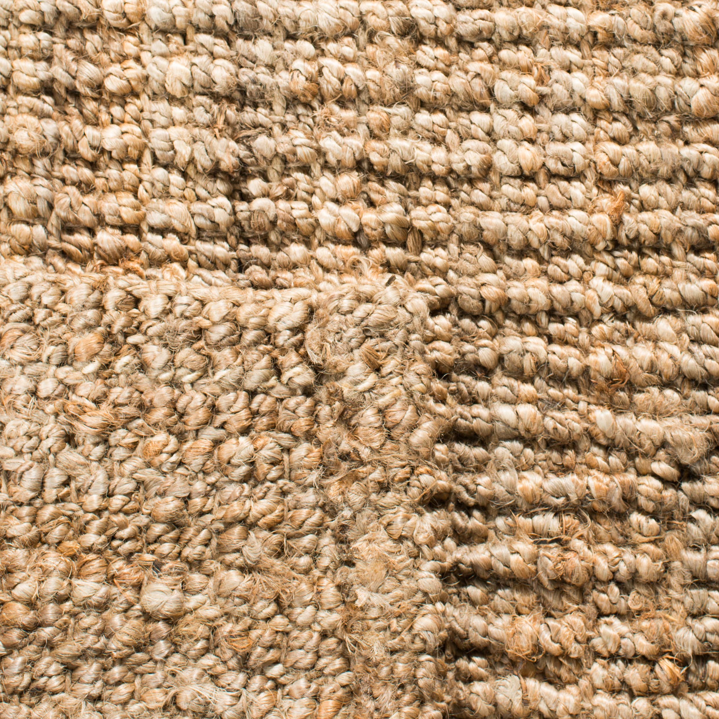 SAFAVIEH rug layered on larger rug illustrating added texture and style