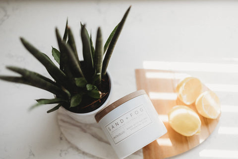 Sand + Fog candle staged in bathroom, adding spa-like fresh coastal scent