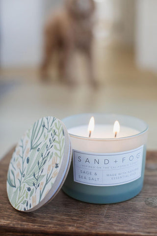 Sand + Fog candle burning in a living room creating calming coastal ambiance