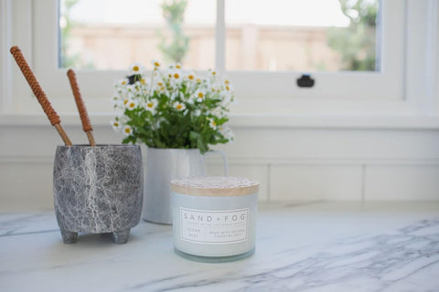 Sand + Fog candle next to common objects to show the 12oz scale benefit