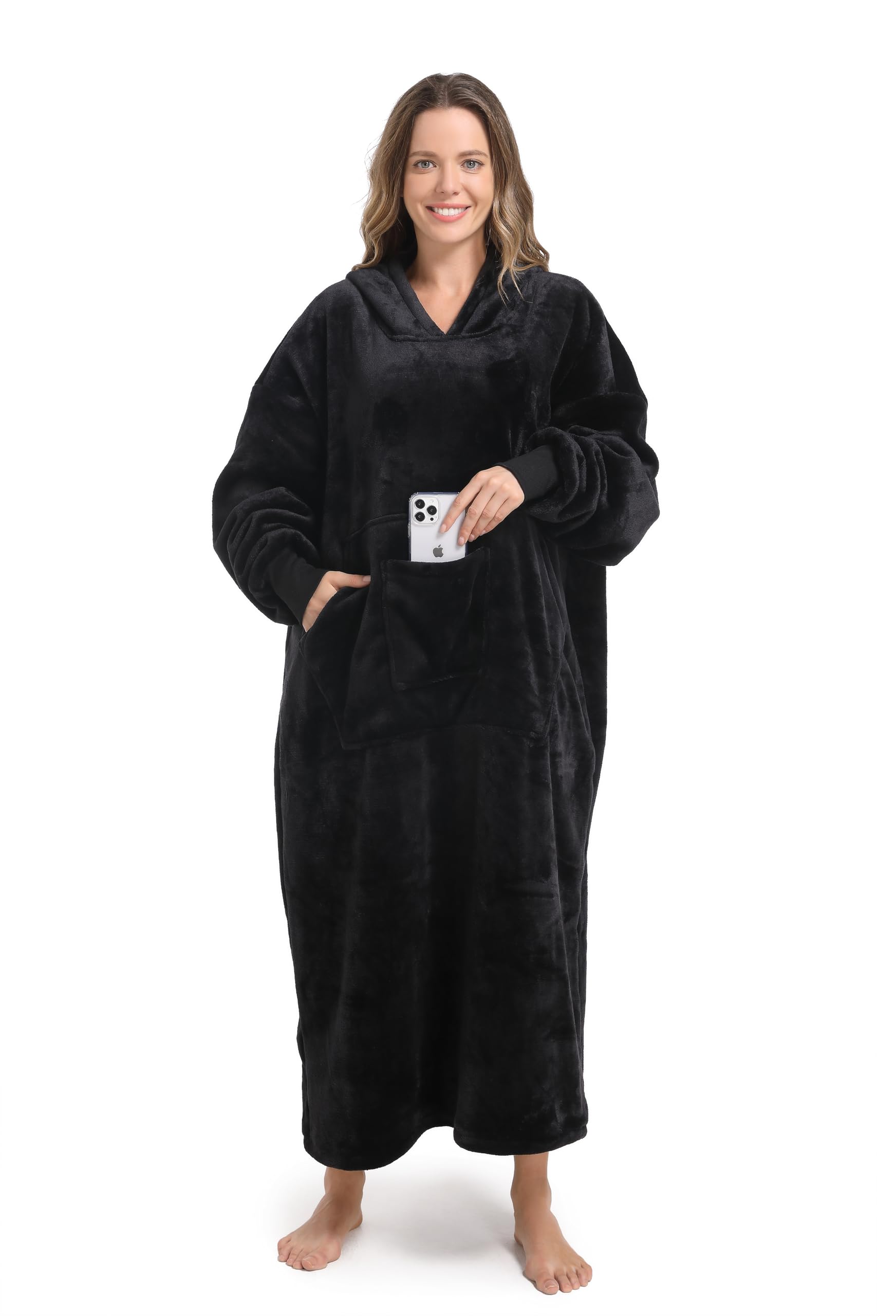 SANDOLONI model wearing hoodie blanket on couch demonstrating cozy at-home comfort