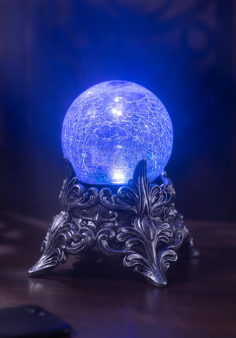Seasons mystic crystal ball illuminated with changing colors creating eerie atmosphere