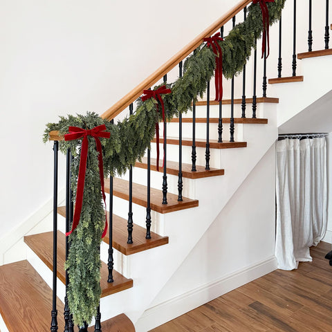 Senjie garland wrapped around stair rail creating elegant staircase styling