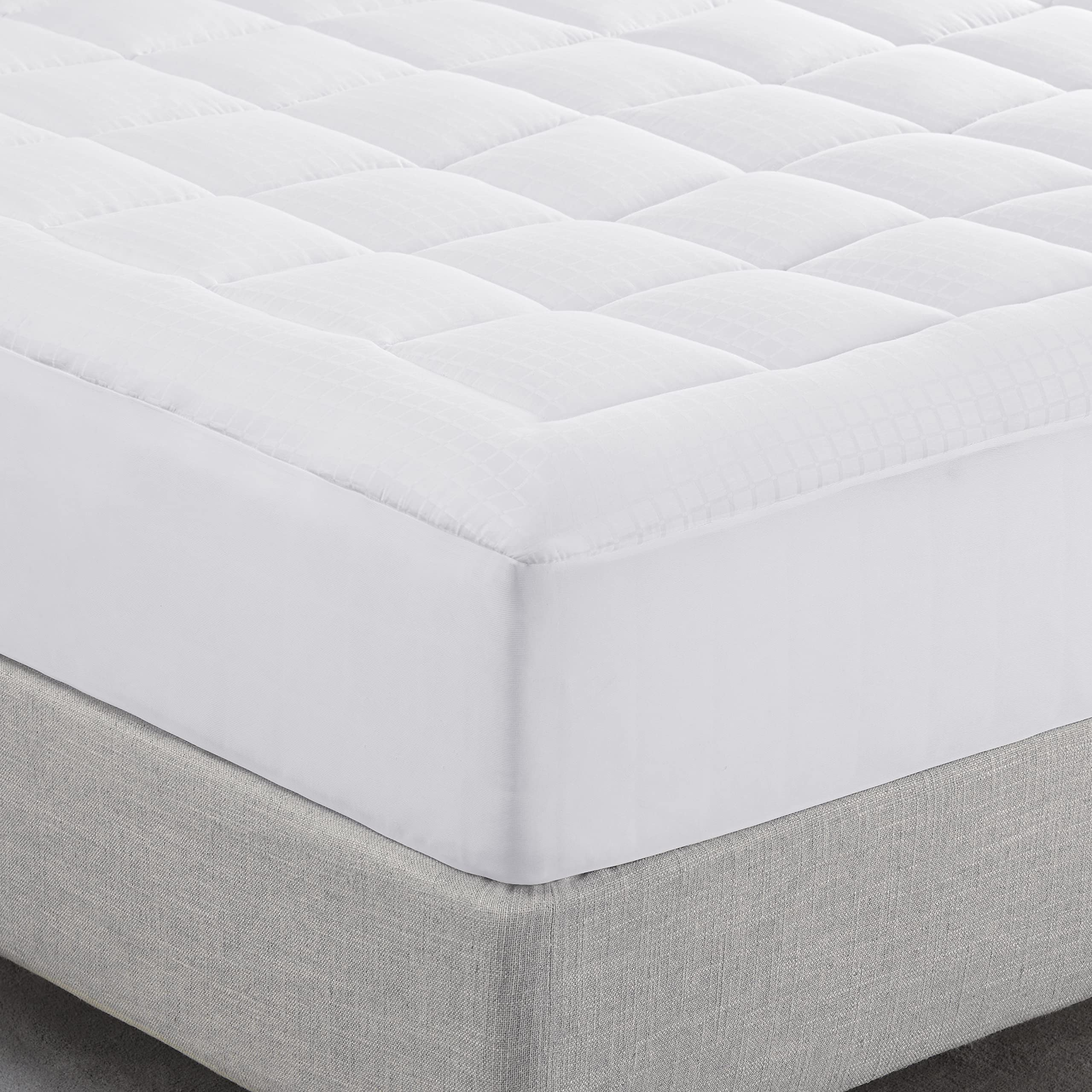 Serta mattress pad styled on made bed illustrating instant comfort upgrade