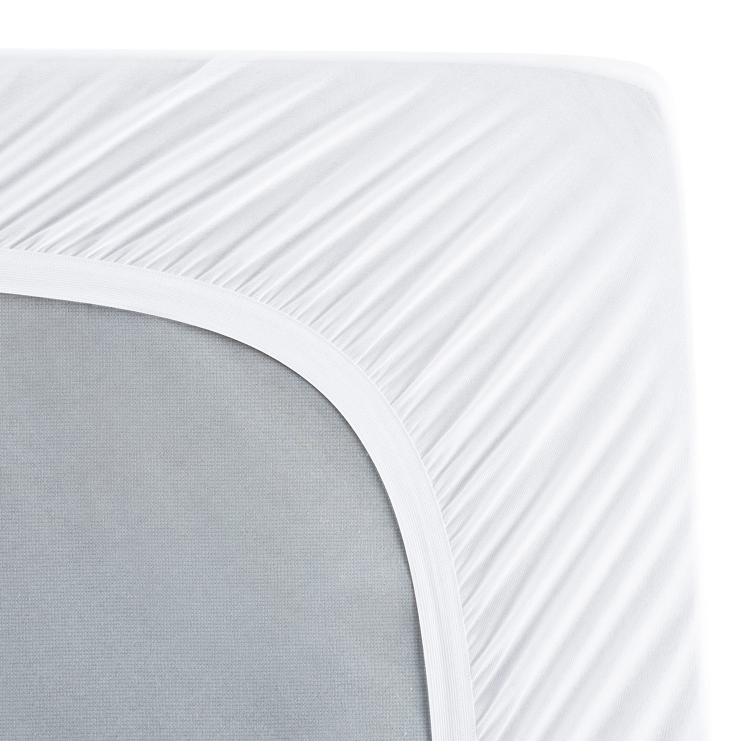 Serta mattress pad being placed in washer showing easy machine-care convenience