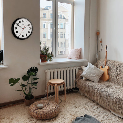 Sharp clock next to a book to show 12-inch size for accurate scale