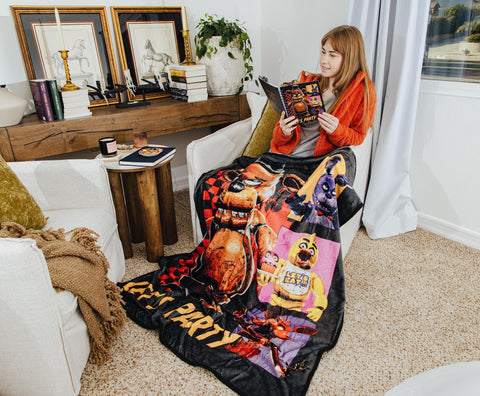 Silver Buffalo blanket styled on bed adding gamer-themed decor and visual impact