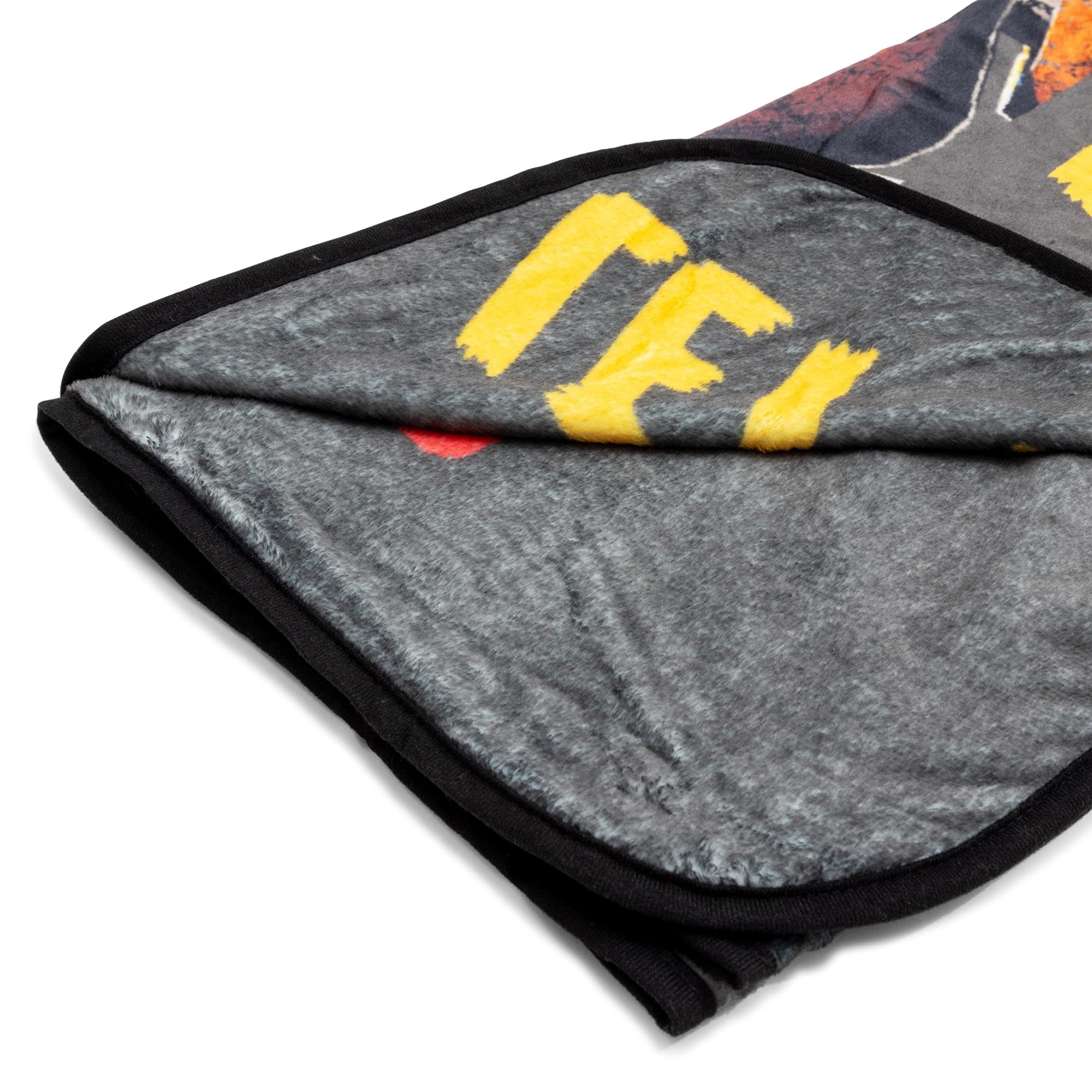 Silver Buffalo throw draped over a sofa conveying cozy gaming or movie-night warmth