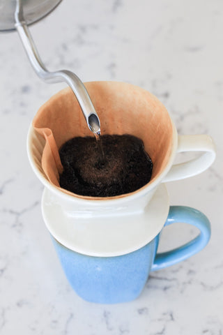 Simply Charmed 40-count Melitta filters pack beside dripper, showing ready-to-brew convenience