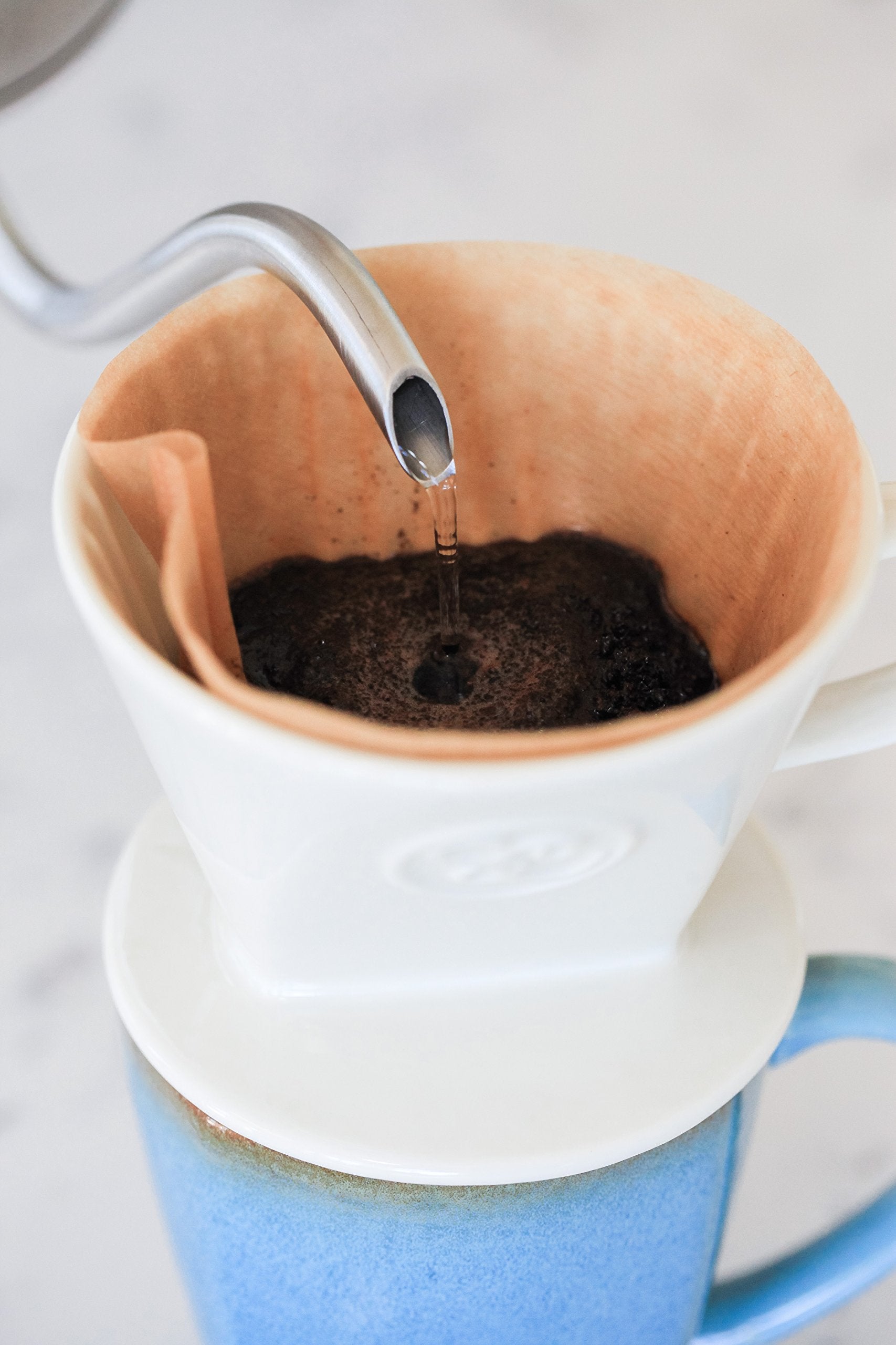 Simply Charmed dripper in use with kettle pouring, illustrating controlled pour-over brewing benefit
