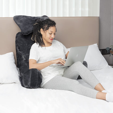 SLIGUY pillow beside a chair showing scale and portability for small spaces