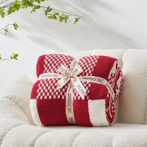 Snuggle Sac draped on sofa adding warmth and stylish red plaid accent