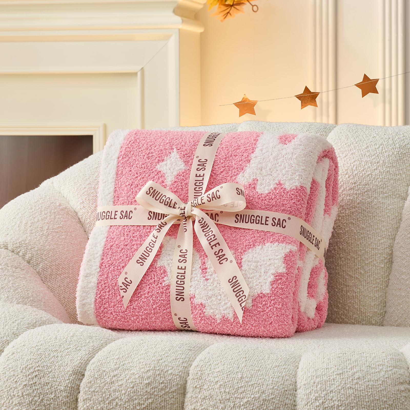 Snuggle Sac folded next to book illustrating portable 50x60-inch size convenience