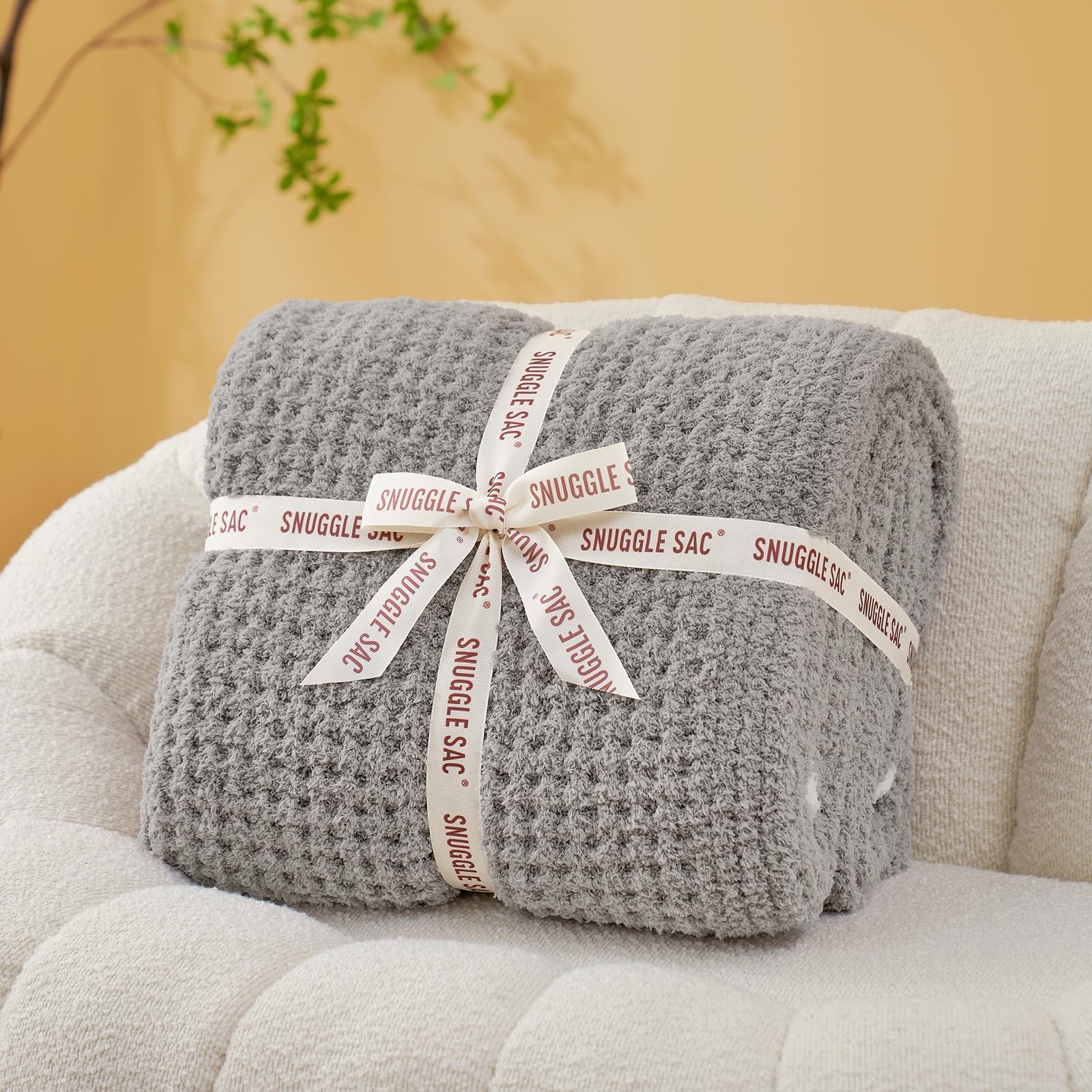 Snuggle Sac front view showing folded throw and ribbon, ready for gifting