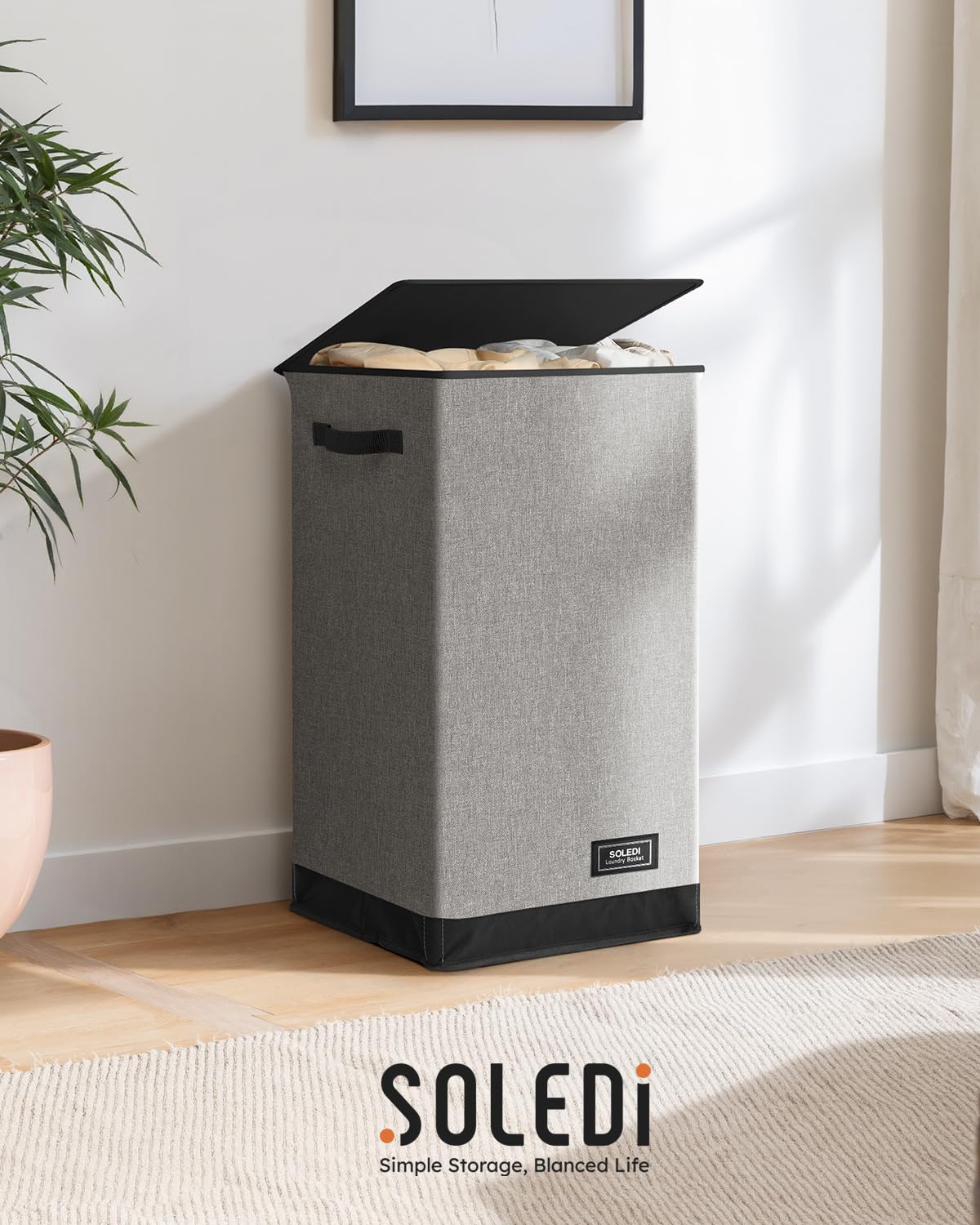 SOLEDI beside a chair for scale comparing hamper height and volume