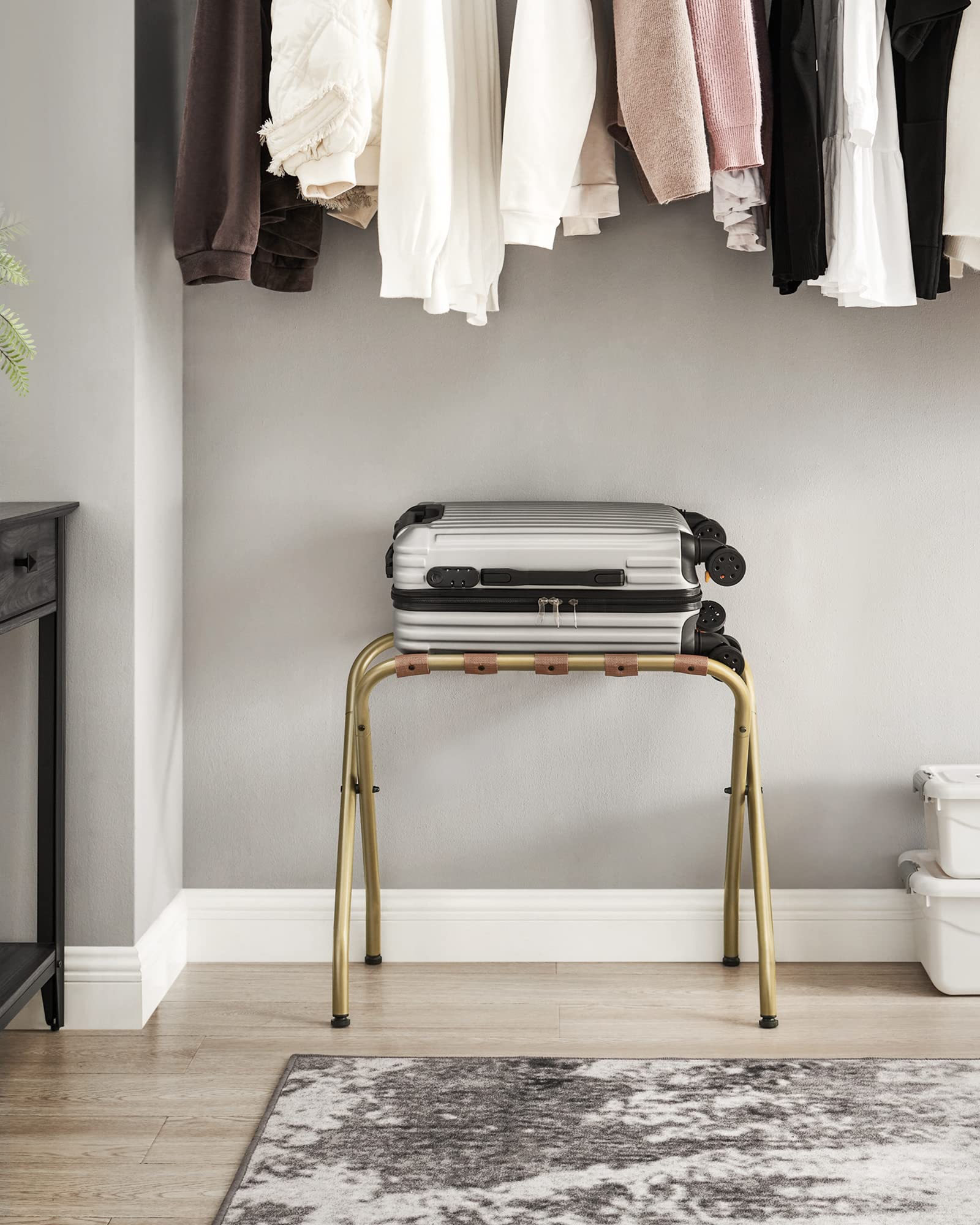 SONGMICS luggage rack stored upright in closet saving space and reducing clutter