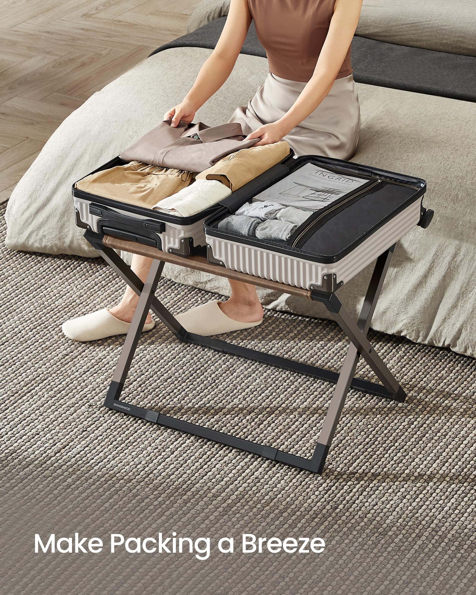 SONGMICS luggage rack in use with suitcase for easier packing access