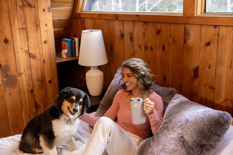 STANLEY mug on a picnic blanket by a campfire, showing rugged outdoor-ready construction