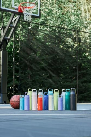 STANLEY bottle on a beach towel showing portable hydration for outdoor adventures
