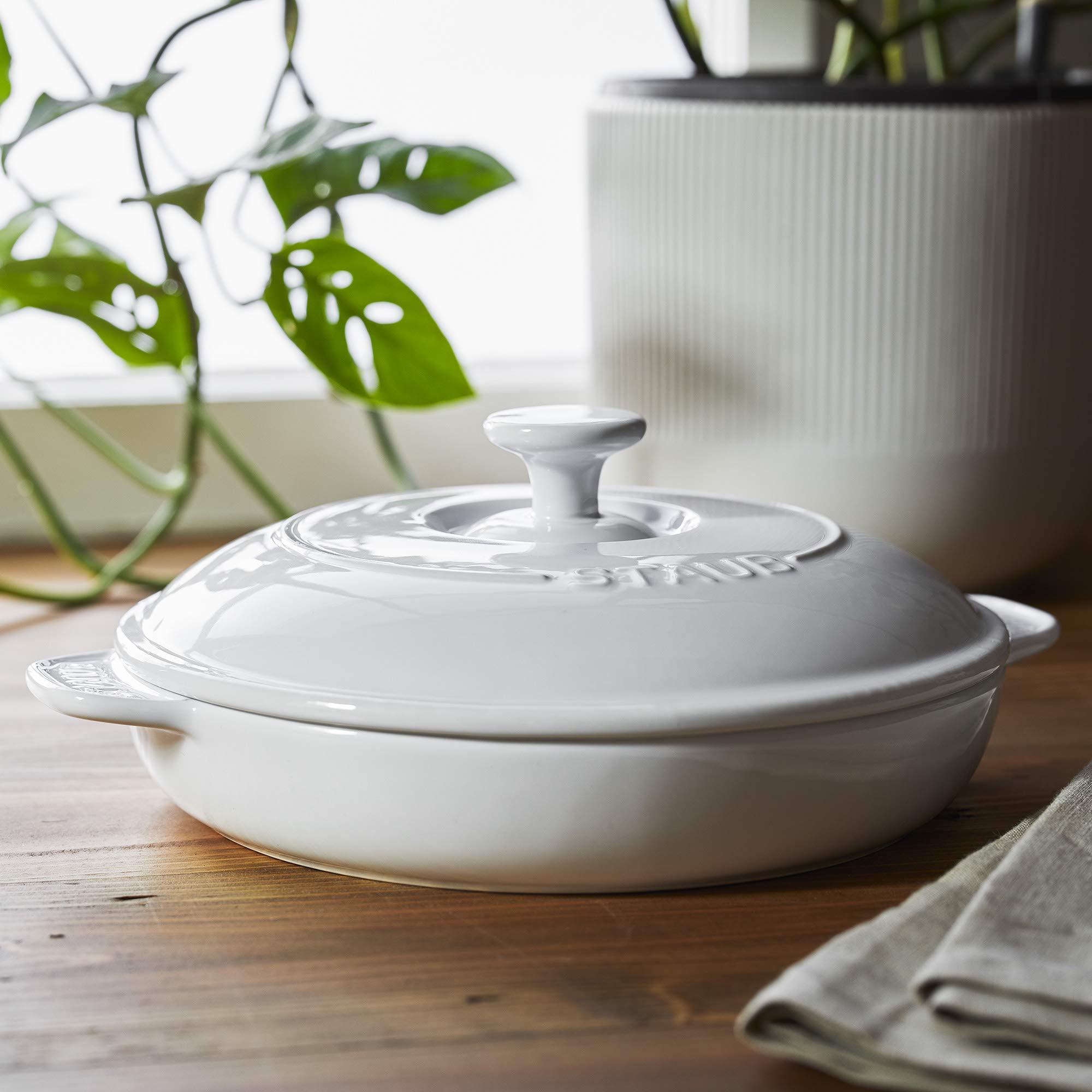 STAUB brie baker lid close-up showing glossy porcelain finish and secure fit