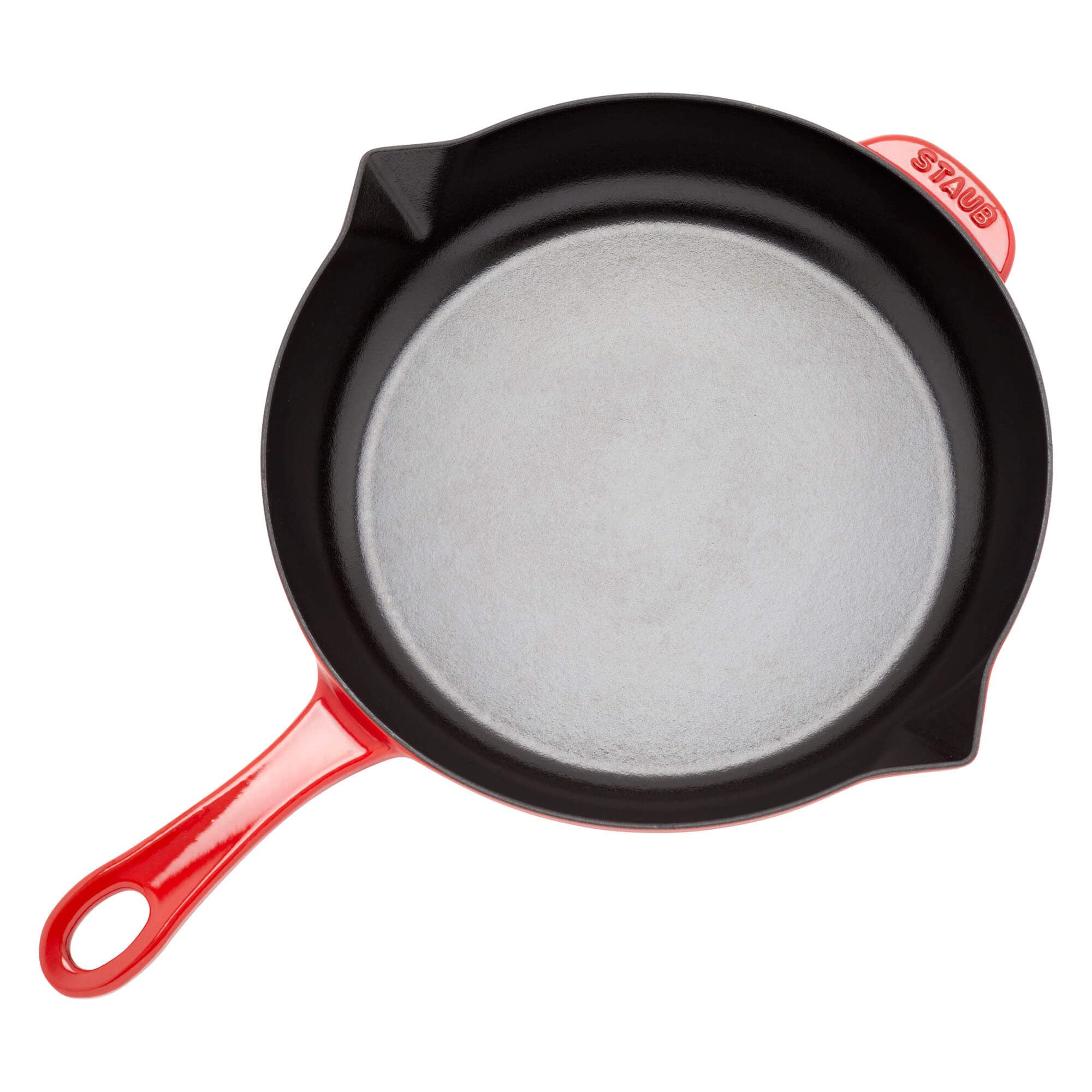 Staub pan searing steak on stovetop highlighting even heat distribution benefit