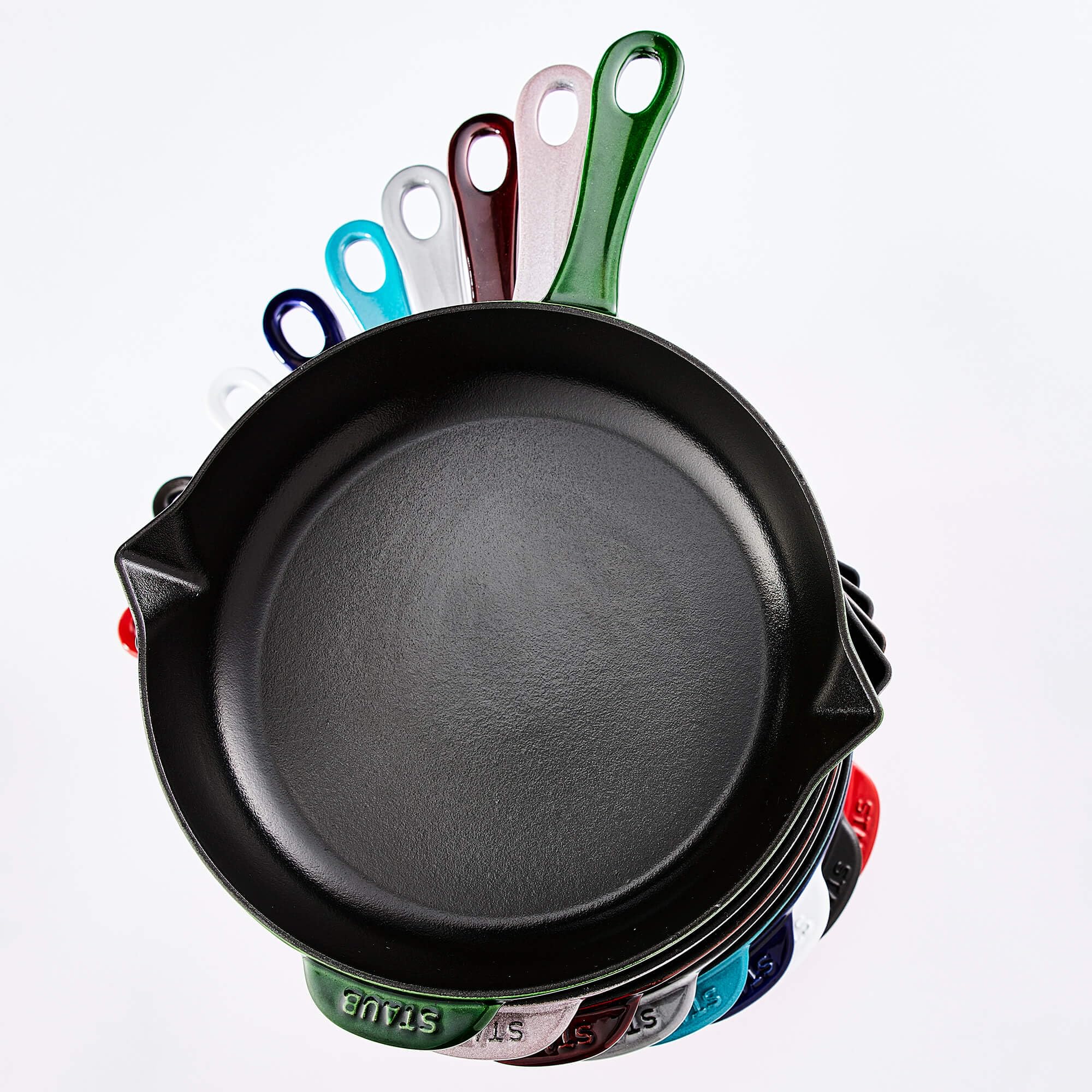 Staub pan next to utensils for size comparison showing practical kitchen fit