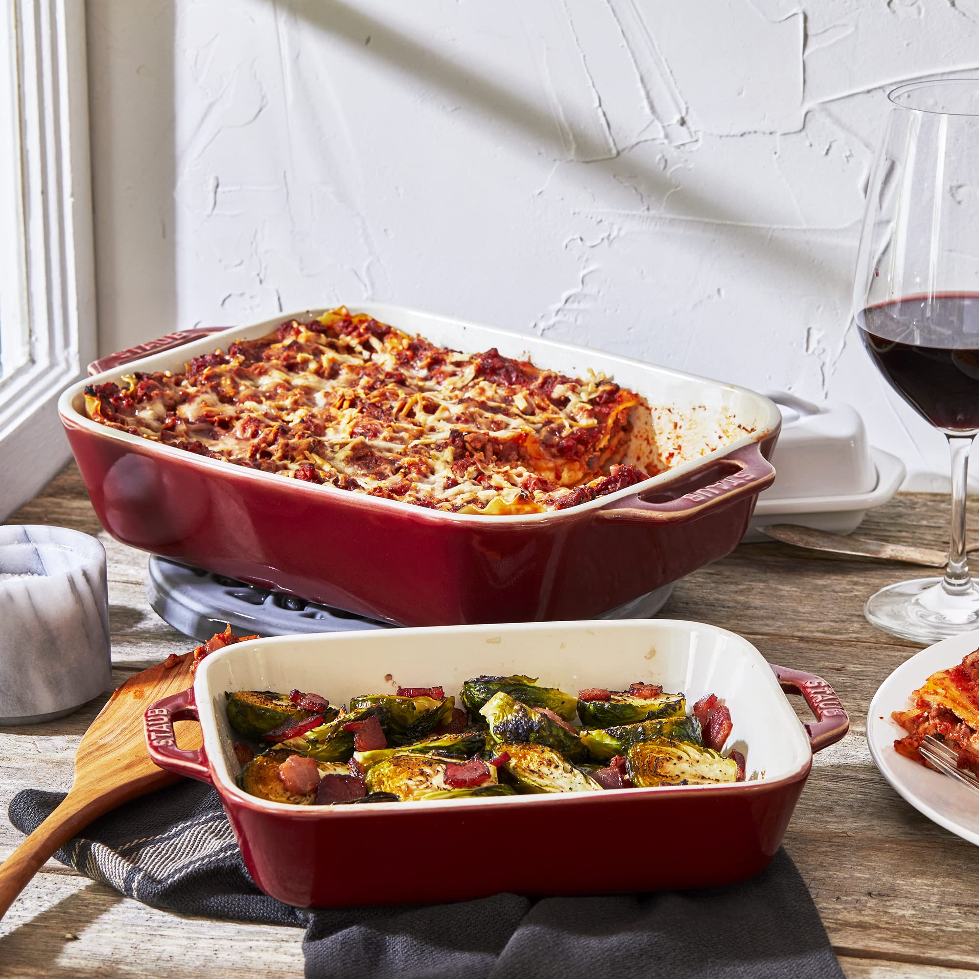 Staub dishes on table serving lasagna highlighting oven-to-table serving appeal