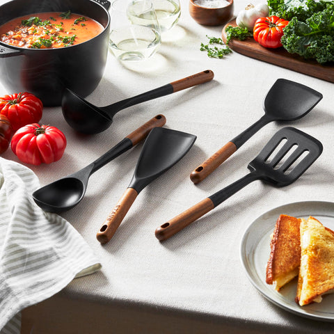 STAUB utensils in use on stovetop flipping steak and stirring, offering reliable control
