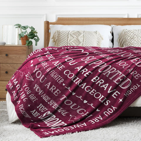 SteadStyle folded blanket beside a book showing compact travel-friendly size