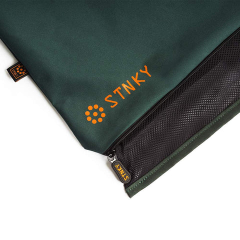 STNKY next to sneakers showing size and capacity for workout kit