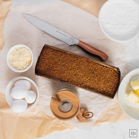 STYLED SETTINGS hand holding chef's knife for scale, balanced weight feel