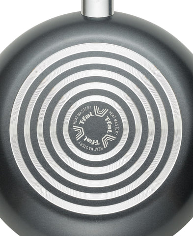T-Fal frying pan in use on gas stovetop demonstrating even heating and cooking control benefit