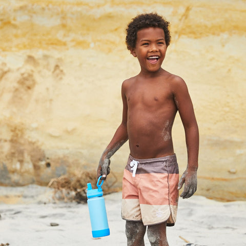 Child holding Takeya bottle by the loop handle demonstrating lightweight carry and independent use