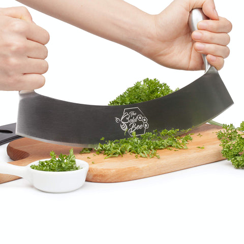 The Bold Bee mezzaluna in use chopping herbs quickly for faster meal prep benefit