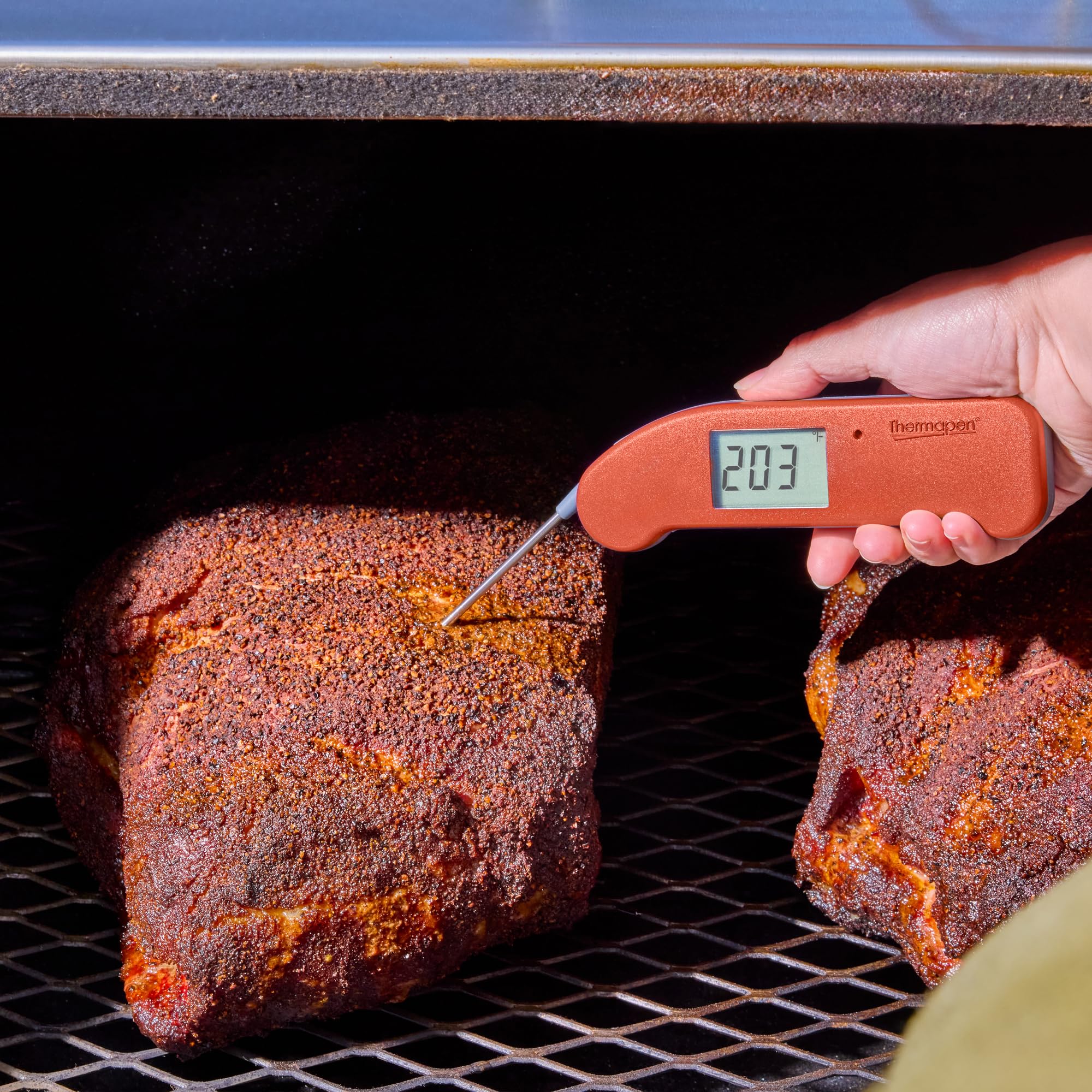 ThermoWorks Thermapen ONE next to a hand for scale showing compact, ergonomic handling benefit