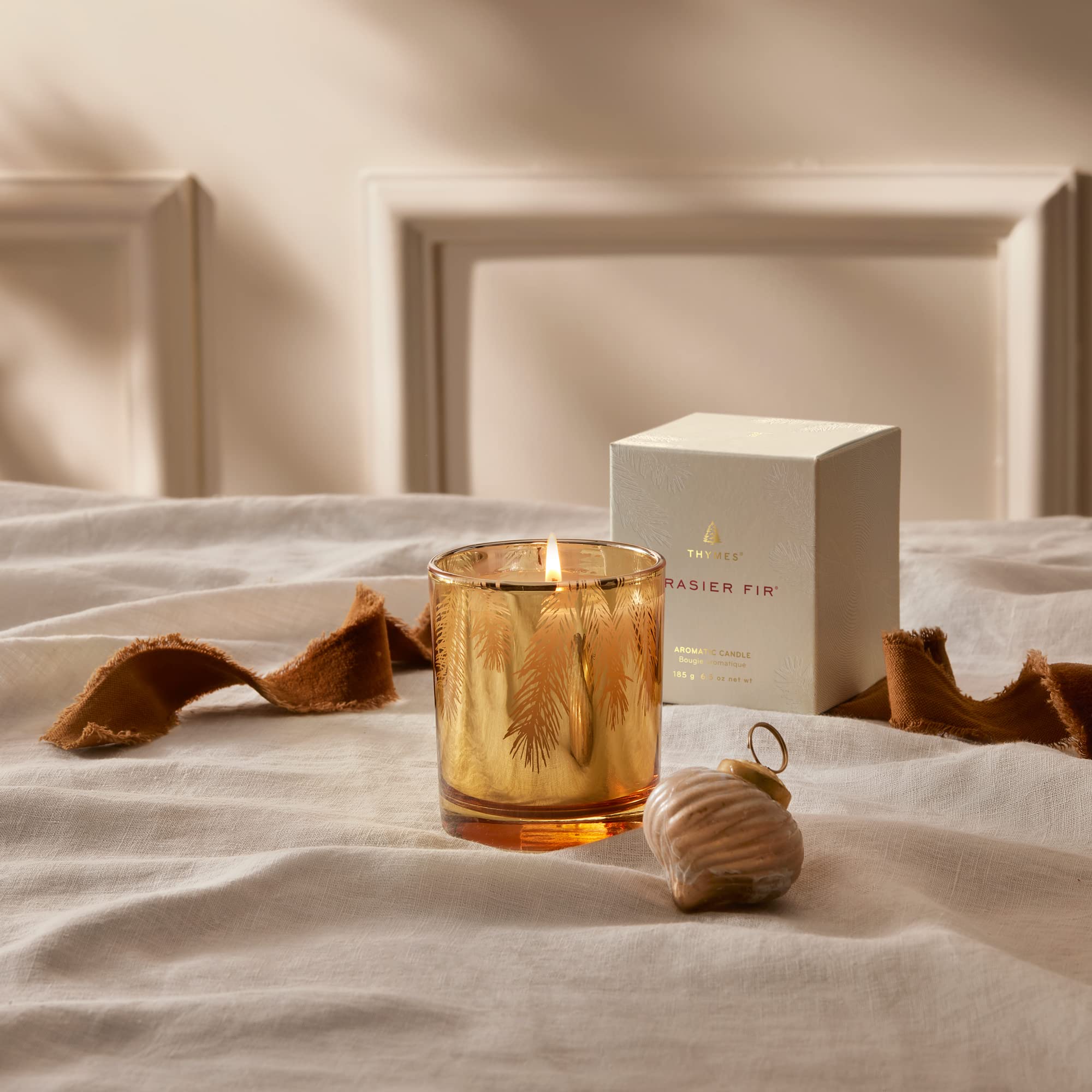 Thymes Frasier Fir lit candle glowing to create warm ambiance and cozy fragrance
