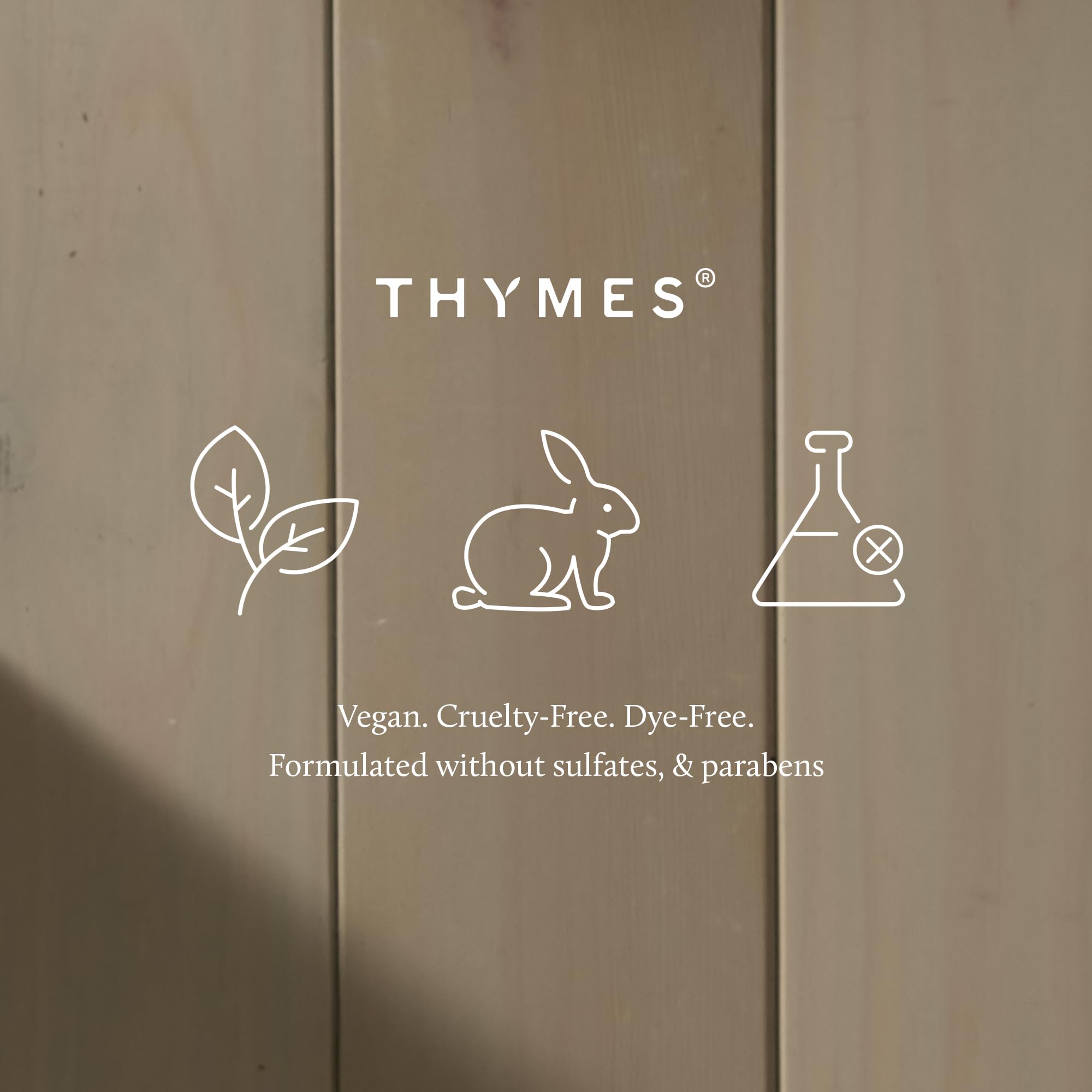 Thymes Frasier Fir tin next to hand showing compact 6.5 oz portability