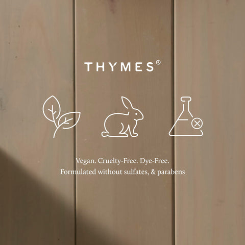 Thymes Frasier Fir tin next to hand showing compact 6.5 oz portability
