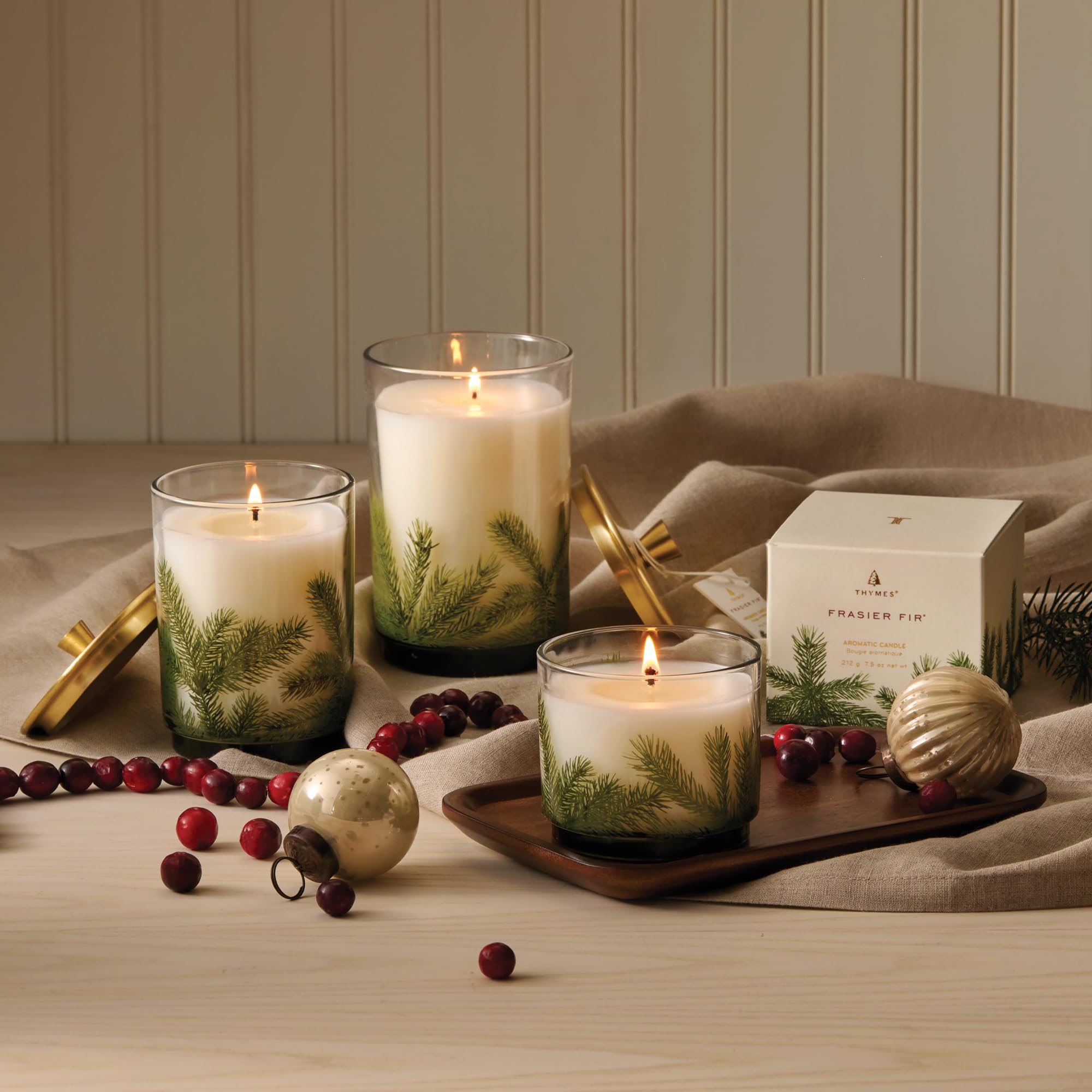 Thymes Frasier Fir beside a mug to show small 7.5 oz scale and convenience