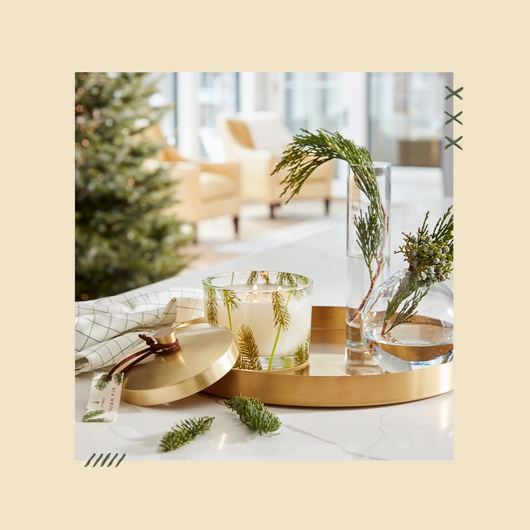 Thymes candle styled on a shelf with greenery to evoke seasonal atmosphere